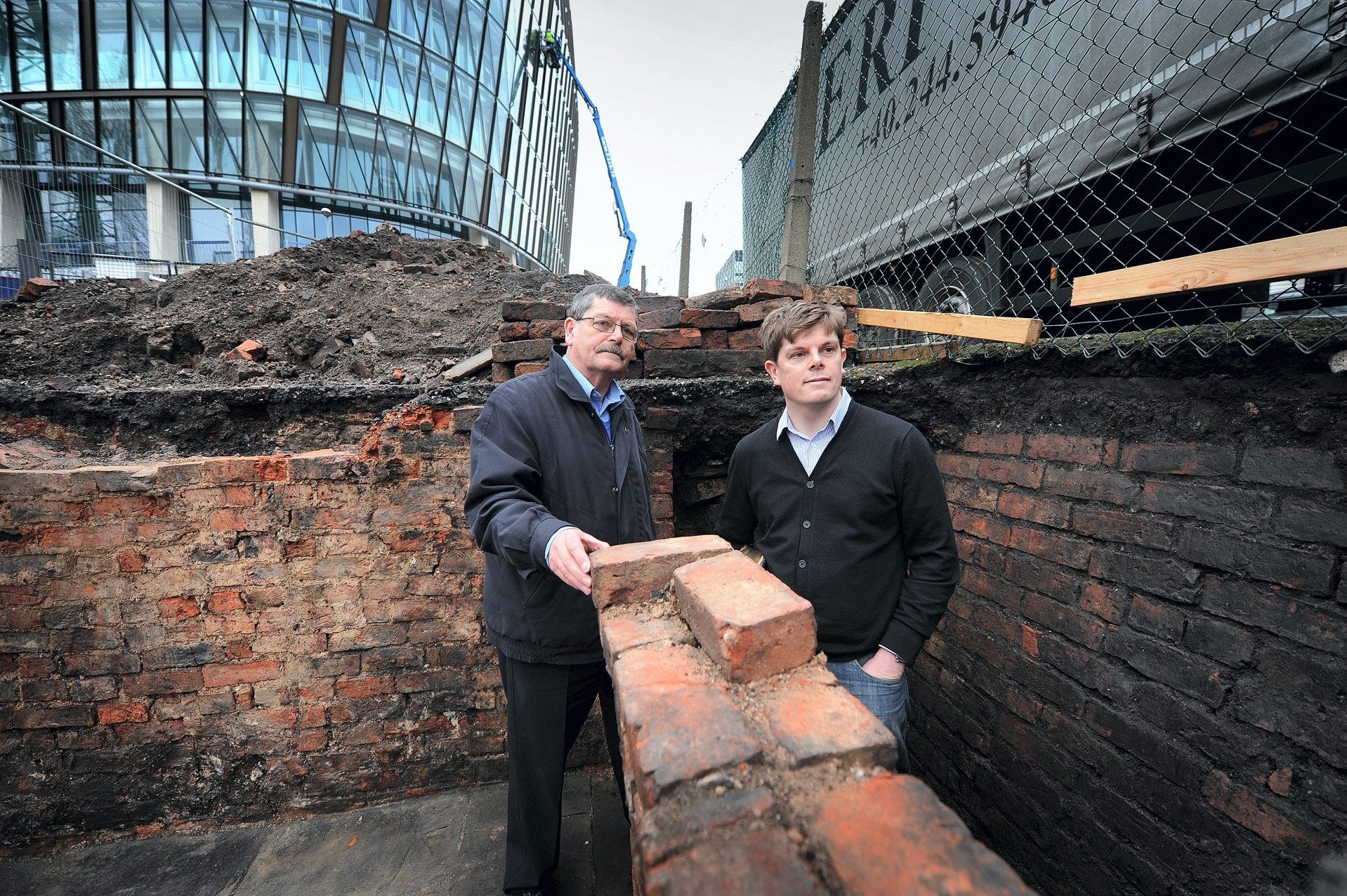 Two men below groundlevel in a brick dig from the 19th century.