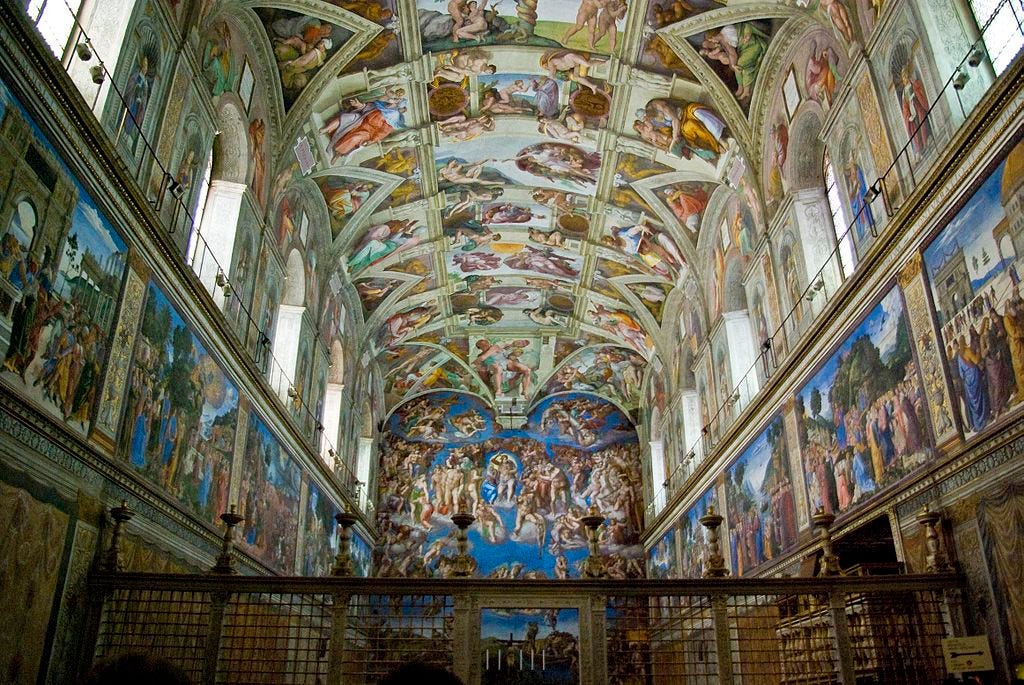 Sistine chapel with its ceiling painted with ornate biblical scenes.