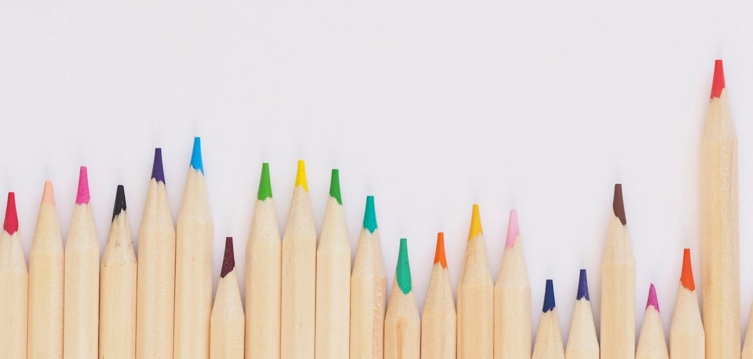 colored pencil lined up on top of white surface