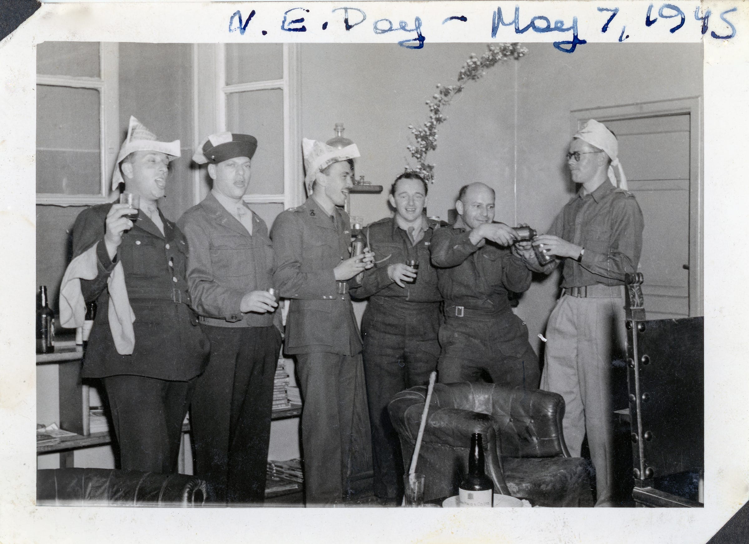 Dressed in full military uniform, wearing a triangular-shaped party hat made from newspaper, and raising a glass of John Haig and Co Scotch Whiskey, my grandpa Norman “Norm” celebrated Victory in Europe (V-E) day in Rome with a few of his fellow Army comrades. 