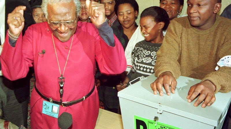 Archbishop Desmond Tutu celebrates casting his vote in South Africa's first democratic election on 27 April 1994.