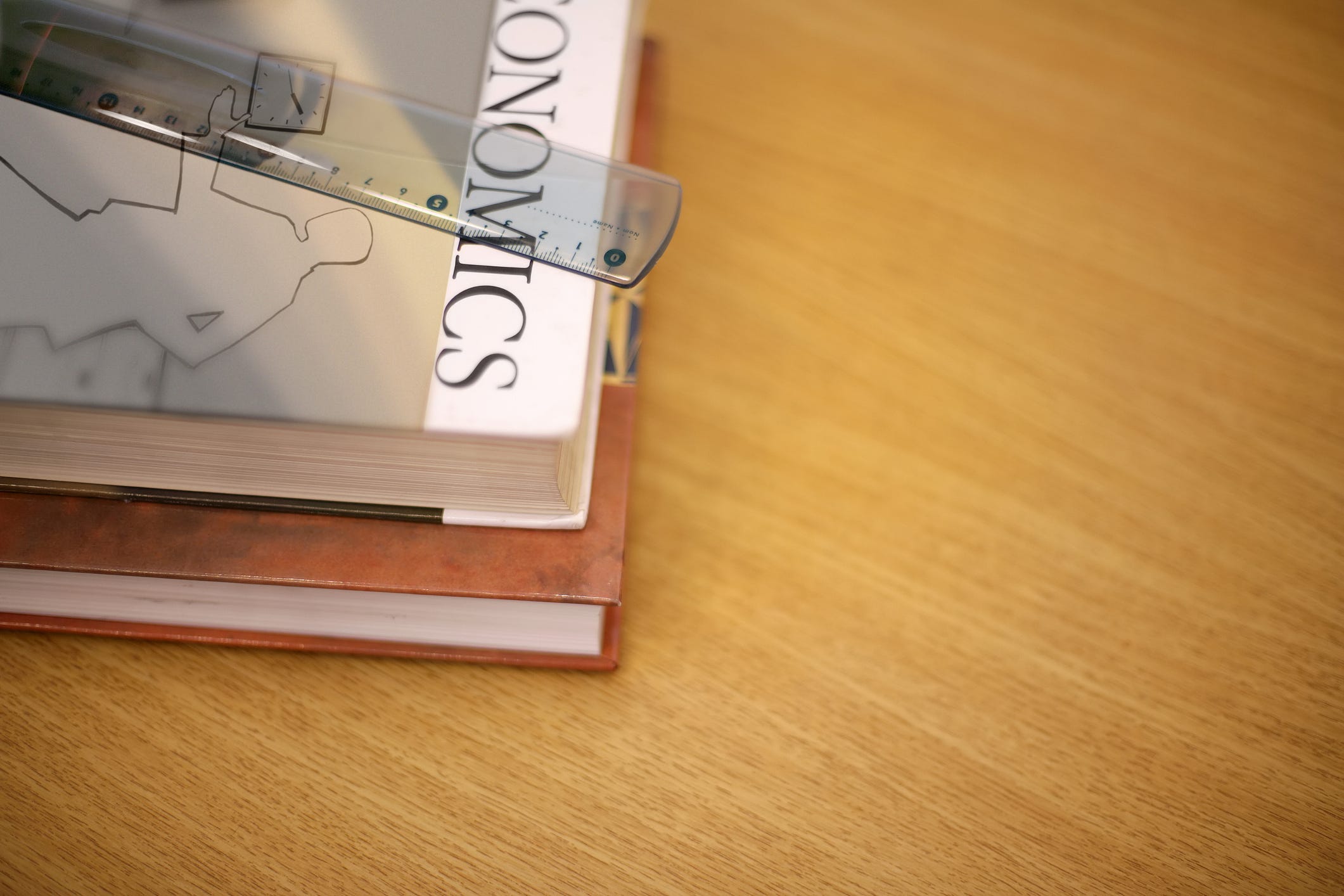 Economics textbooks sit on a desk.