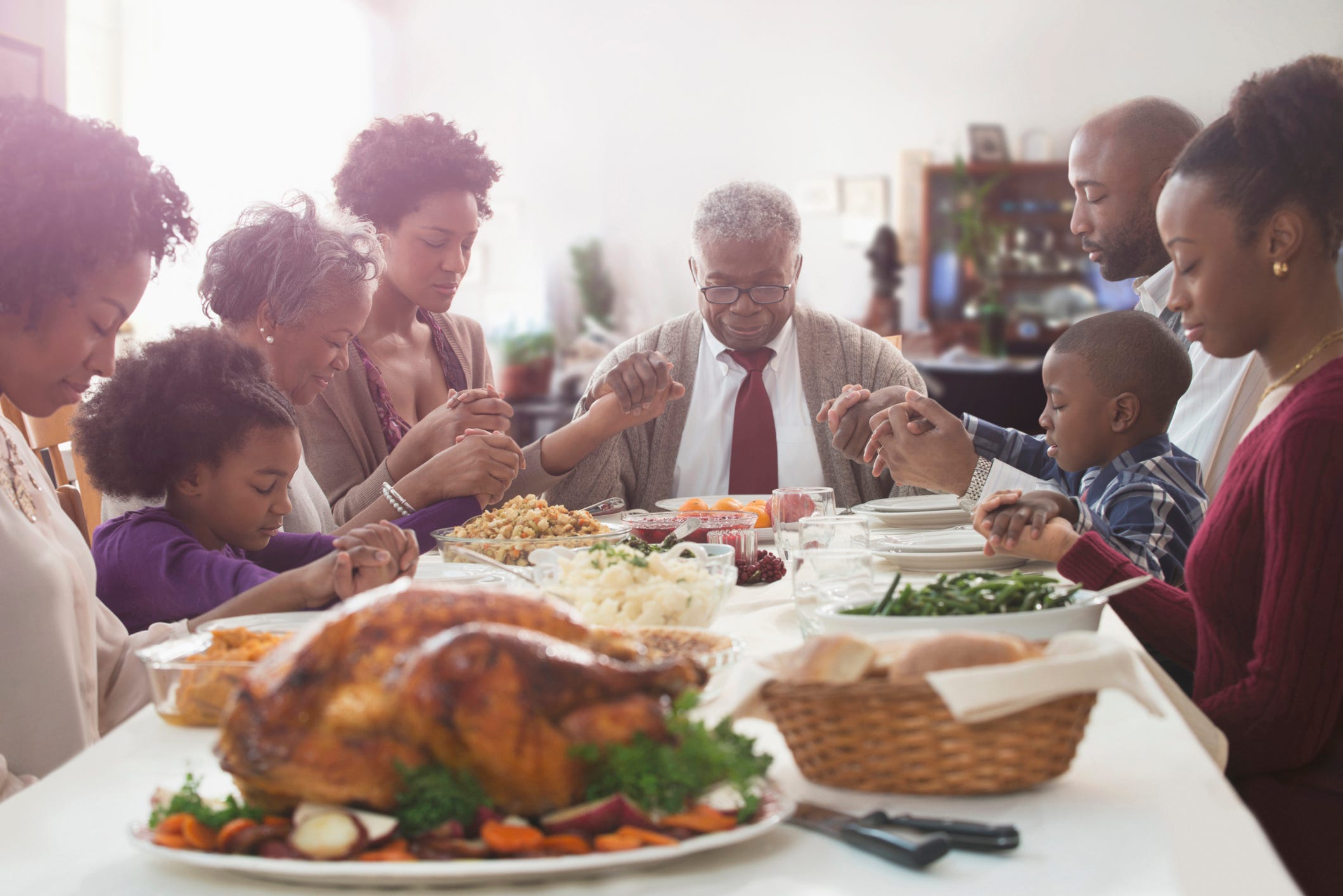 A family says grace around the Thanksgiving table.