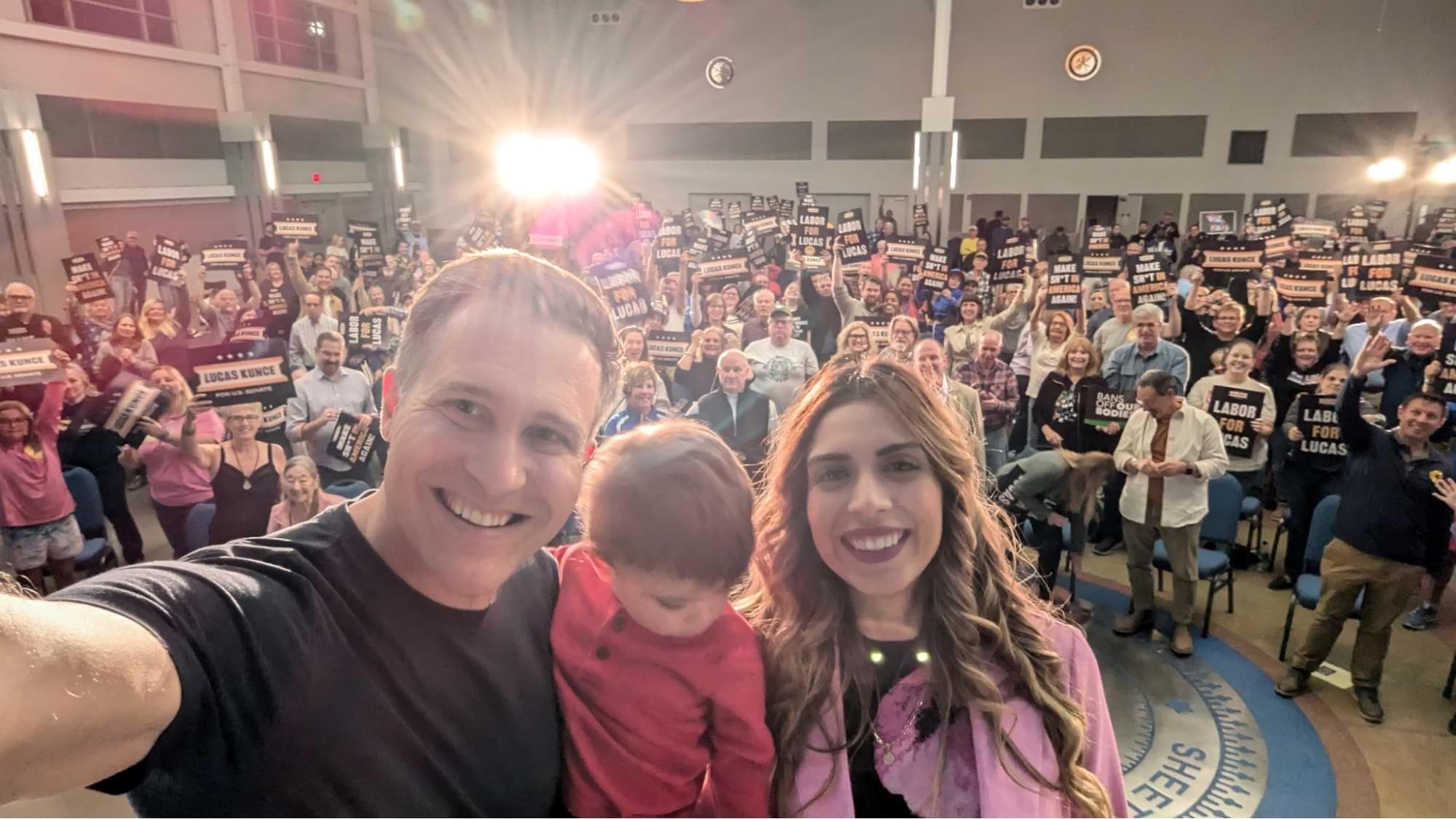 Photo of Lucas, Marilyn, and Harvey in front of a crowd of supporters in St. Louis.