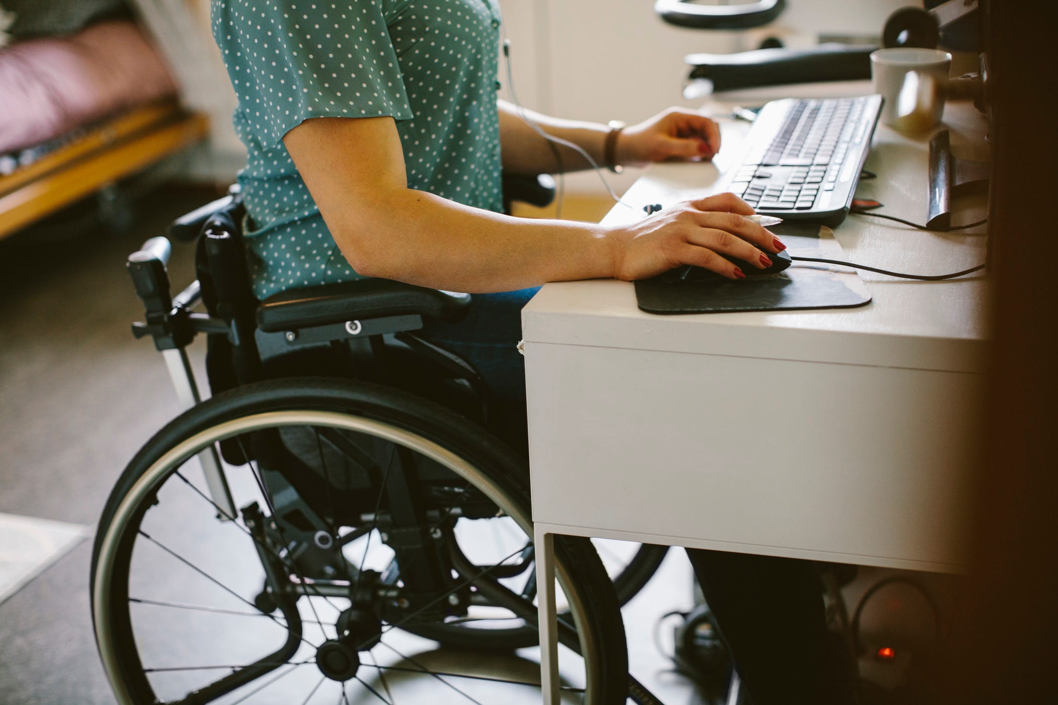 A disabled woman works at a desk.