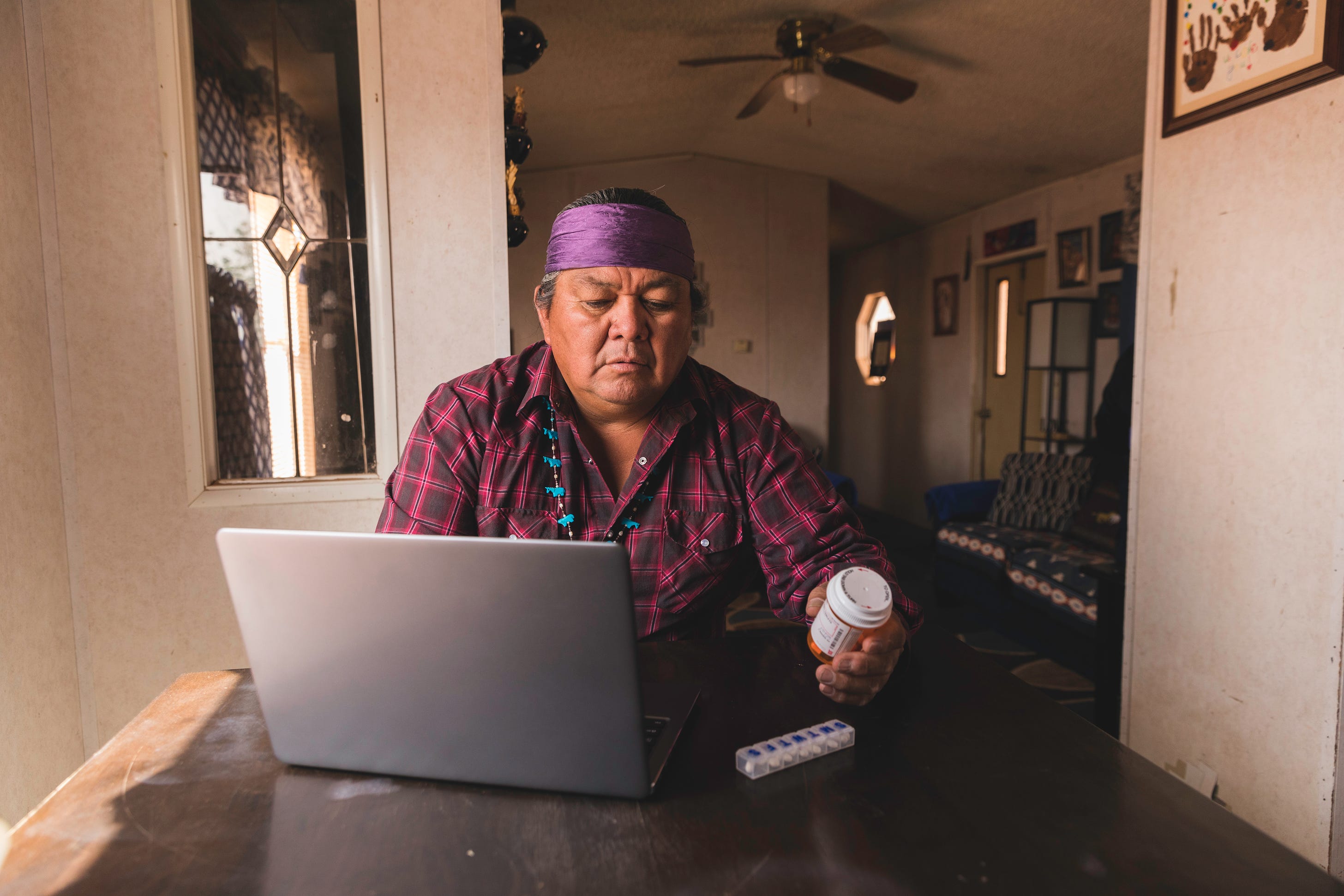 A Navajo man refills a prescription online. Increasing internet access on reservations will provide more telehealth opportunities for Native Americans. Image Credit: RichVintage/Getty Images