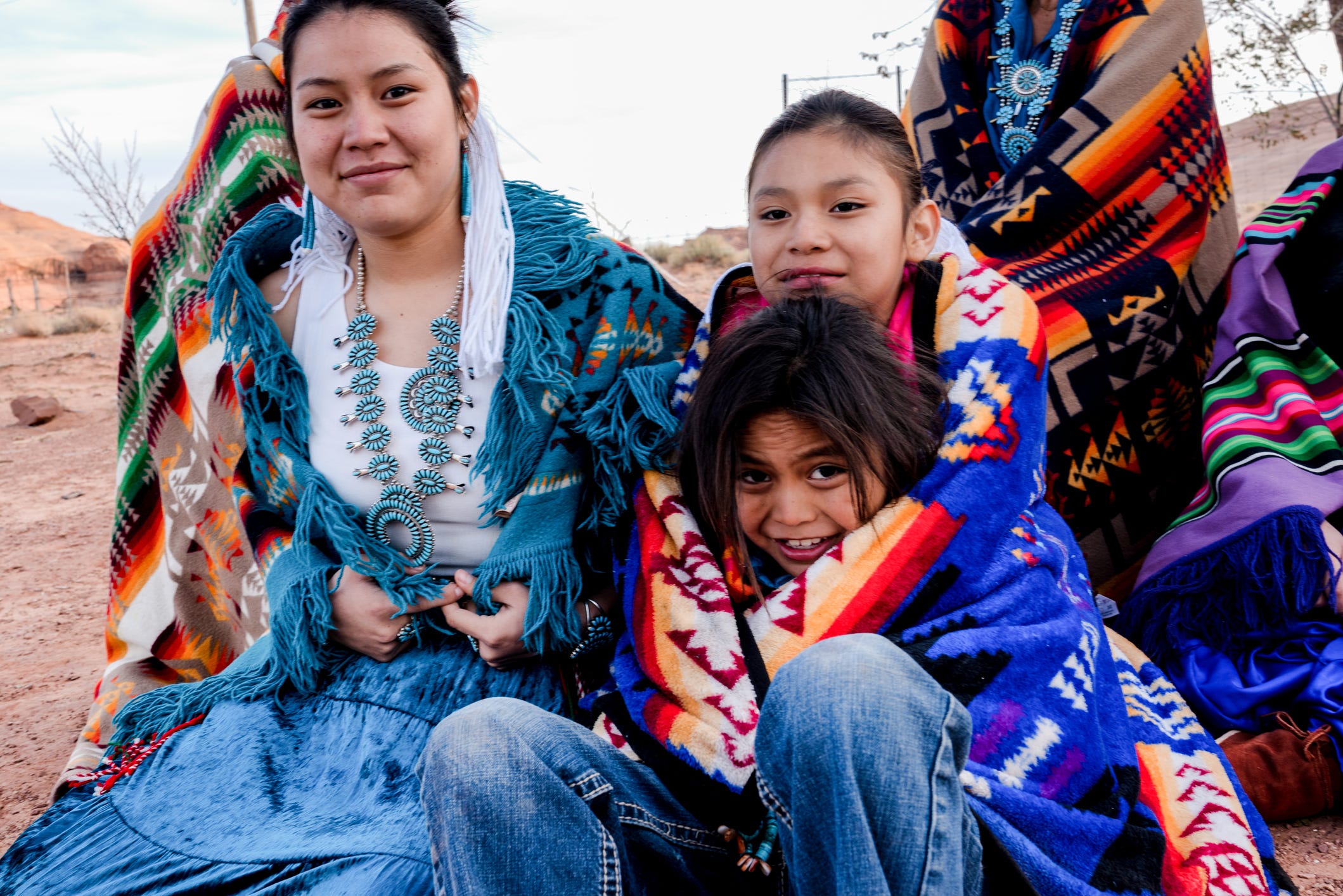 A Native American family sits together.