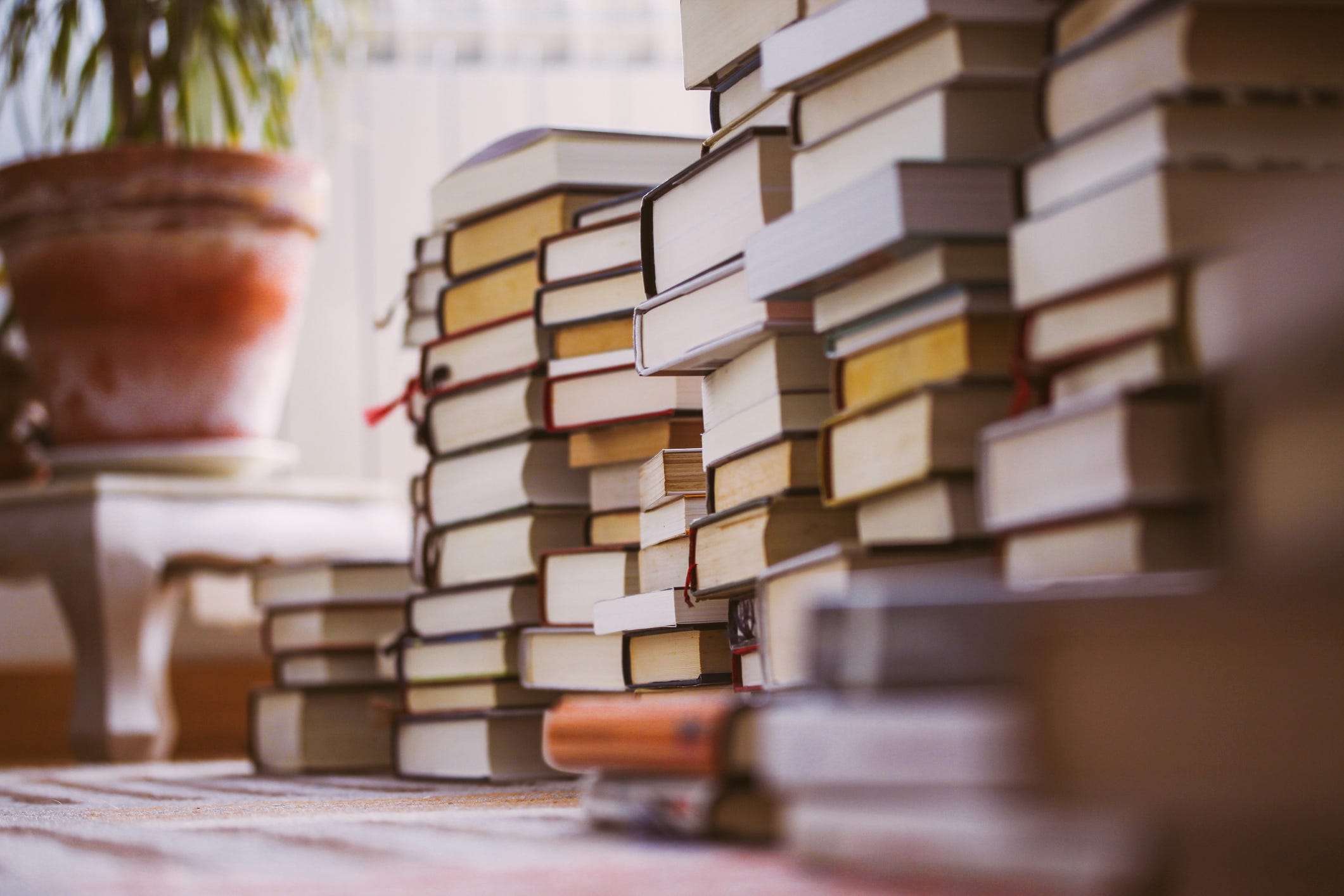 Piles of books on a living room floor.