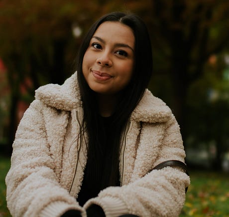 Photo of Paula Perez sitting outside wearing a fuzzy white jacket