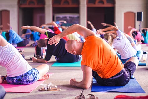 People in a yoga class, a man walking with his dog, a family out for a walk, a woman exercising, a person lifting weights, a person running.