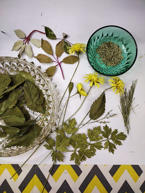 Wildflowers made of paper, including nettle and bramble leaves, catsear, buttercups and birdsfoot trefoil