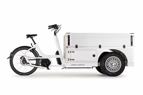 The tender is a tricycle cargobike with two wheels at the front. A gallery of images showing different combinations of Tender cargobikes. One has nothing on, just a platform. Another has a large storage box and another has a large flight case