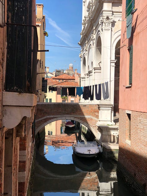Pictures of Venetian canals and buildings, as well as details from the trip like a meal, a chandelier, and a picture of the water.