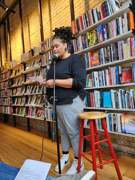 Various poets standing or sitting in Milkweed Bookstore, in front of filled bookcases, reading poetry.