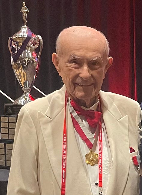 Ed smiling in 3 photos: one wearing medals and with a trophy in background, one in a large meeting, and one on stage being recognized by 2 other men