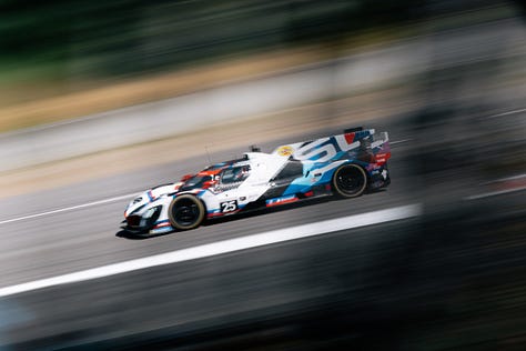 The No. 24 and No. 25 BMW M Team RLL racecars speed across Laguna Seca during the IMSA Monterey round in May 2025. Photos by Walter Fulbright.