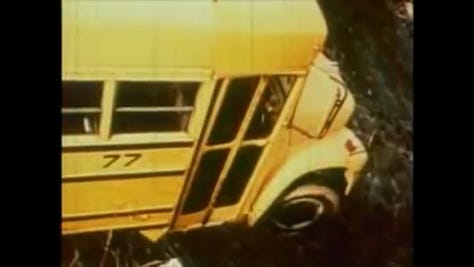 A pickup truck drives the bus off the road and it dangles over a cliff.