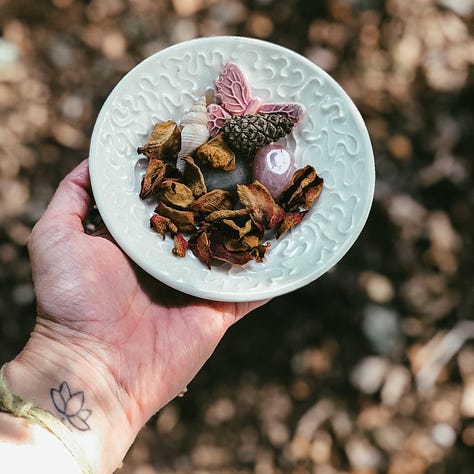 1. Circle centrepiece with a log, flowers, shells and a candle. 2. A small altar with a large shell, a candle in a tin, pinecone, feather, selenite crystal, moss stick and a stone. 3. A hand with a lotus tatoo at the wrist holding a small white bowl with dried rose petals, small shell, ceramic butterfly and pinecone.