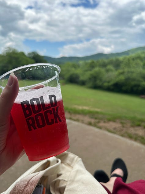 The program for Twenty-Sided Tavern | A table with mythological-themed props | A cup of cider in front of a beautiful mountain landscape