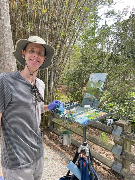 A man paints a swamp and marsh scene inside a botanical garden, which included baby aligators.