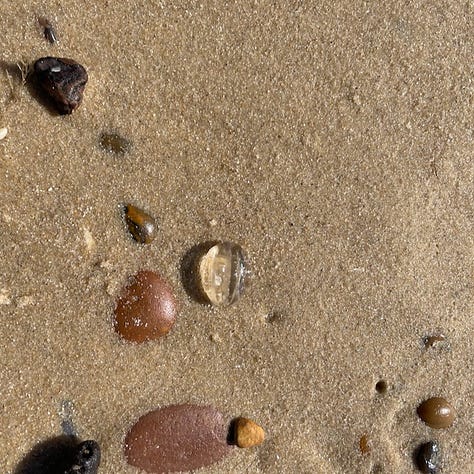 lucky hole stone, heart stone, baby jelyfish on sand