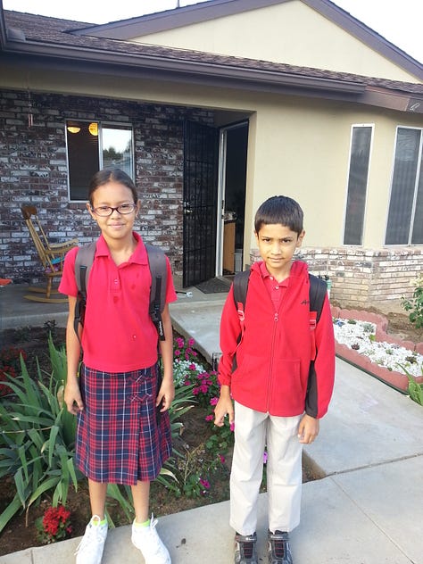 children in school uniform on front porch