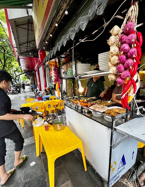 the Religion Publishing House, a pho stand, people cooking meat on the street for banh mi and bun cha, and Craft Link, a social enterprise shop encouraging economic development and helping rural women support themselves by "seeking new markets for traditional artisans."    