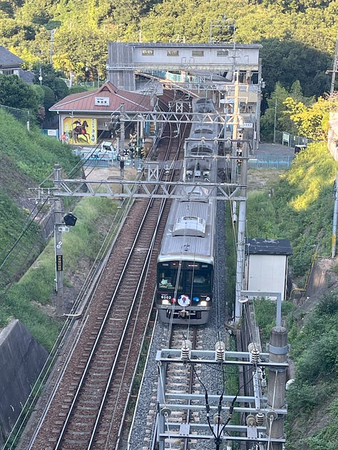 Pictures of riverside, a train leaving a small station, a passageway so small it looks like a culvert, and the suburbs of Kobe