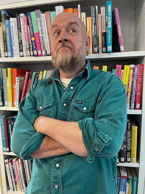 Three photos of comedian George Egg standing in front of a bookshelf of cook books, wearing a green shirt and with his arms crossed.