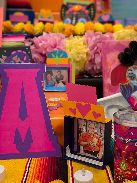 Colorful Day of the Dead altar with candles, flowers, and offerings.