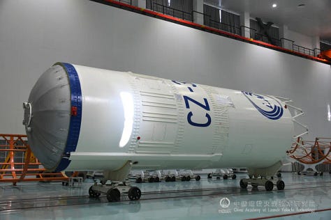 One of the Long March 3B/E's boosters being lifted during preperations, the rockets second-stage following equipment installation, and the vehicles fairing with the asteroid program's logo.