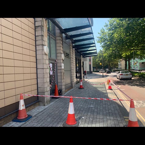 Images of the front door of a building where the glass canopy has been cracked and the area below has been sealed off with cones and orange and white tape
