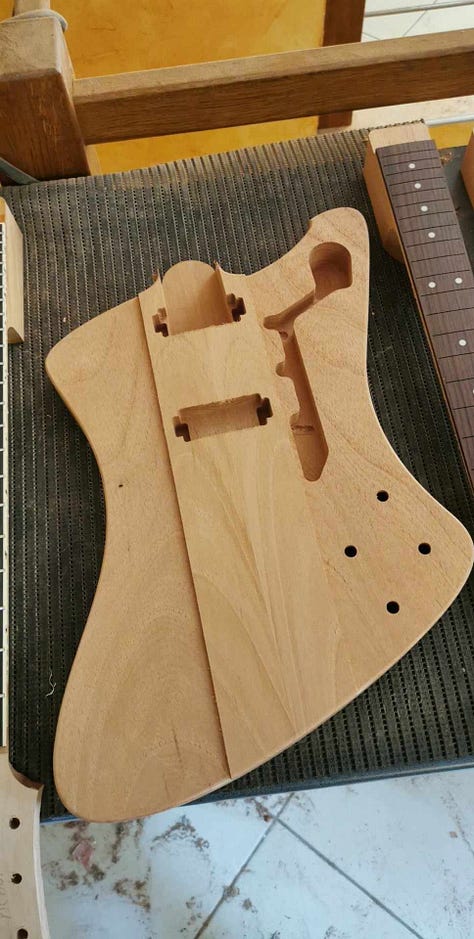 Pictures of the cutout body blank and the neck before and after the fingerboard is glued.