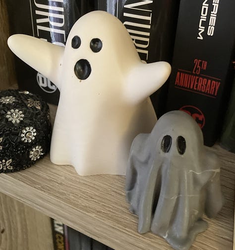 A jar of loose leaf fruit tea, a sweary garden sign, two marshmallow keyrings, two resin ghosts on a bookshelf, a birdfeeder filled with alpaca wool, and two alpacas with friendly faces.