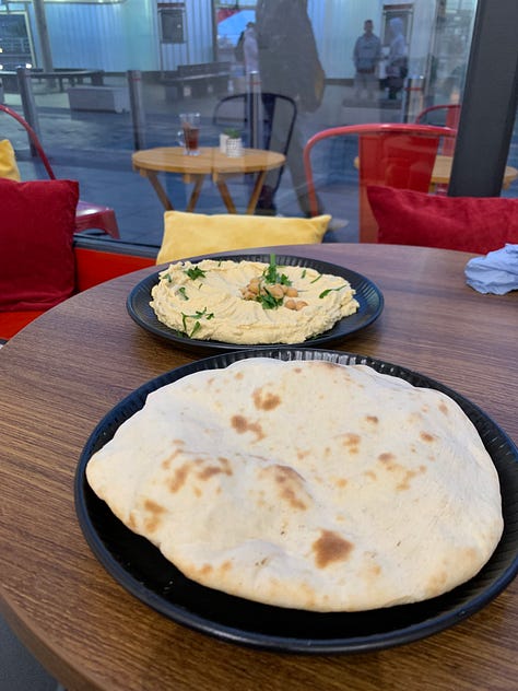 Pitta bread with humus, a toasted pitta and a plastic cup with juice