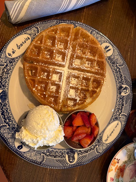 A picture of the U.S. Capitol building, recognizable by its iconic dome and surrounded by trees, likely taken from a garden or park nearby. A close-up of a plate with a waffle, ice cream, and what seems to be a side of strawberries. The plate is ornate, with a traditional blue-and-white pattern and the name "Li'l Louis's" written on it. A detailed view of a fresco or painted ceiling, likely the Apotheosis of Washington, found in the dome of the U.S. Capitol Rotunda.