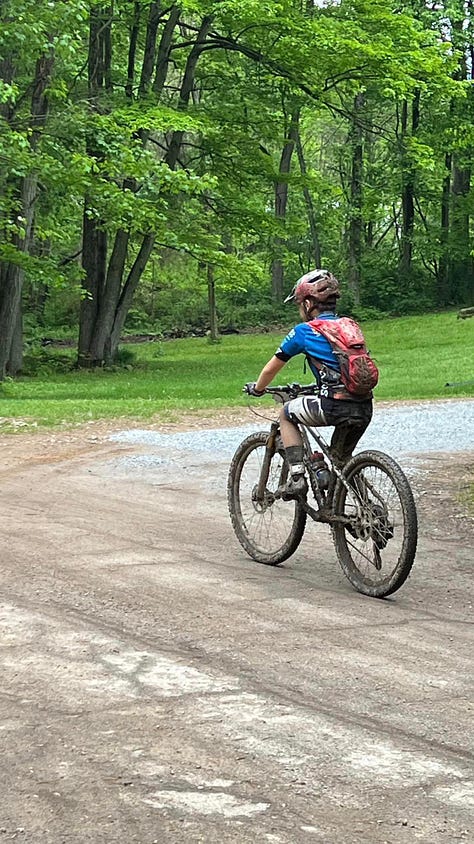 Alex Liu, the youngest person ever to finish the Mohican MTB 100 race, holds his face in his hands during the Mohican Mountain Bike 100 race.
