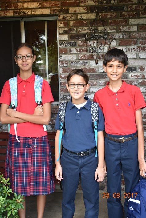 children in school uniform on front porch