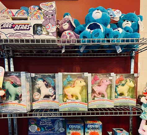 Left: girl standing in front of candy bins. Middle: open shelves with Care Bears, My Little Ponies, and other toys. Right: open shelves with Lite-Brites and other classic toys.