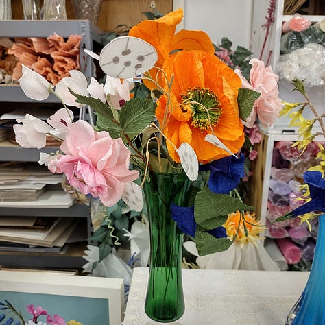 A colourful selection of gladioli, crocus, narcissus, daffodils, tulips, Icelandic poppies and morning glories, all made out of vibrant shades of crepe paper