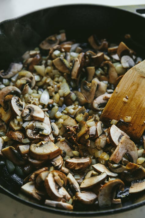 Creamy mushroom chicken in a skillet and on a plate with cauliflower mash.