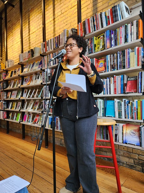 Various poets standing or sitting in Milkweed Bookstore, in front of filled bookcases, reading poetry.
