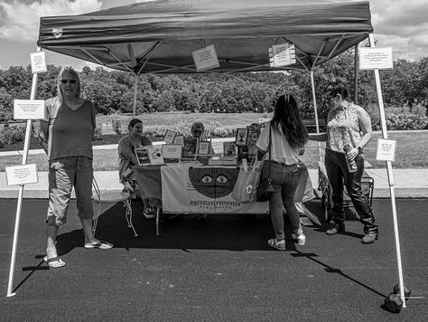 Several photos of a tent outdoors at a vendor fair. The open tent has books on a table and different people reading the books.