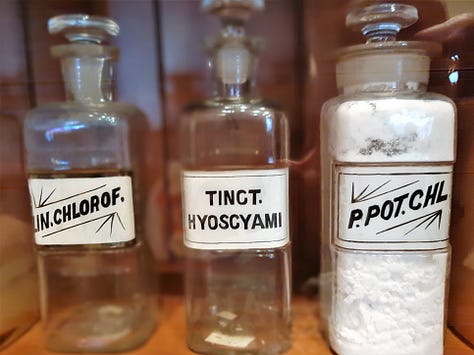 Original medicines in their bottles and a small sign that sits beside the jar of leeches.