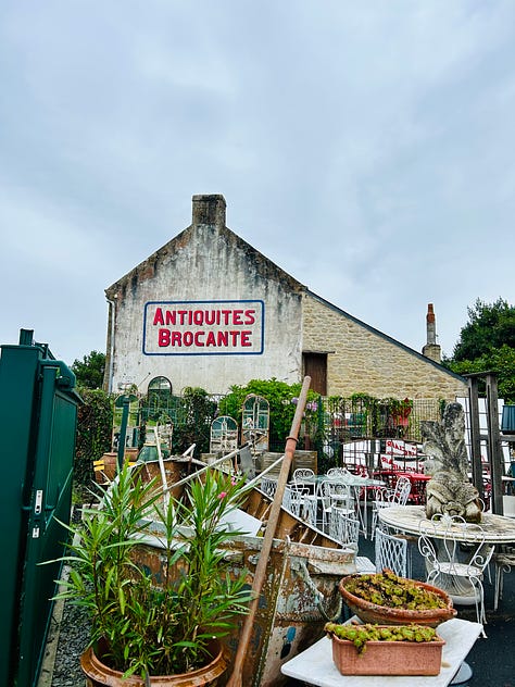 an evening harbor filled with boats; restaurant sign offering oysters and wine, a seafood platter; a breakfast picnic basket