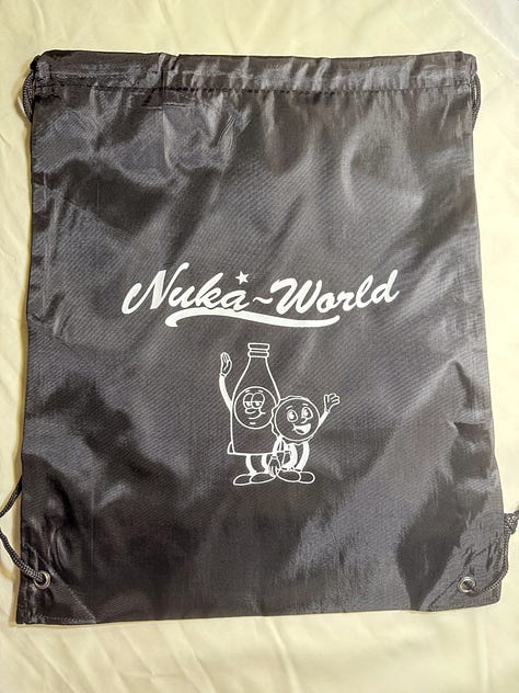 Red and black drawstring bags with Nuka World and picture of Bottle and Cappy