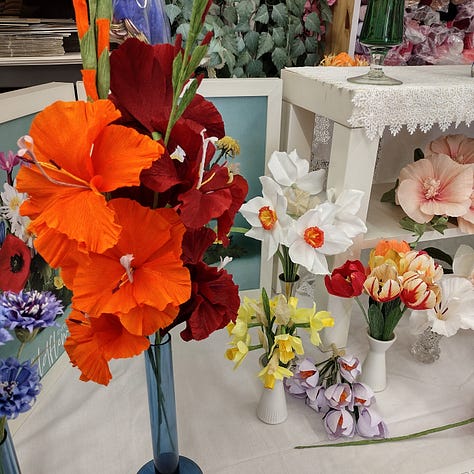 A colourful selection of gladioli, crocus, narcissus, daffodils, tulips, Icelandic poppies and morning glories, all made out of vibrant shades of crepe paper