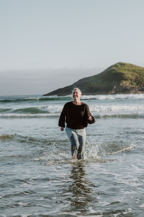 Photographer Tamara Dayle runs fully clothed in the Pacific Ocean outside Tofino BC 