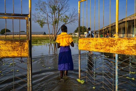Nine images from conflict photographer Lynsey Addario including trans sex workers in NYC, women in Afghanistan, American troops in Afghanistan, girls in a classroom in Afghanistan, Gambian refugees in a boat, a COVID patient in Britain, a heroin addict in Glasgow, a woman wading through floodwater in Sudan and a firefighter fighting the California wildfires.