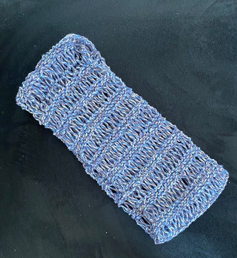 Red fingerless mitts with a cable design, marled blue, blue and lavender cowl, blue and white headband/earwarmer